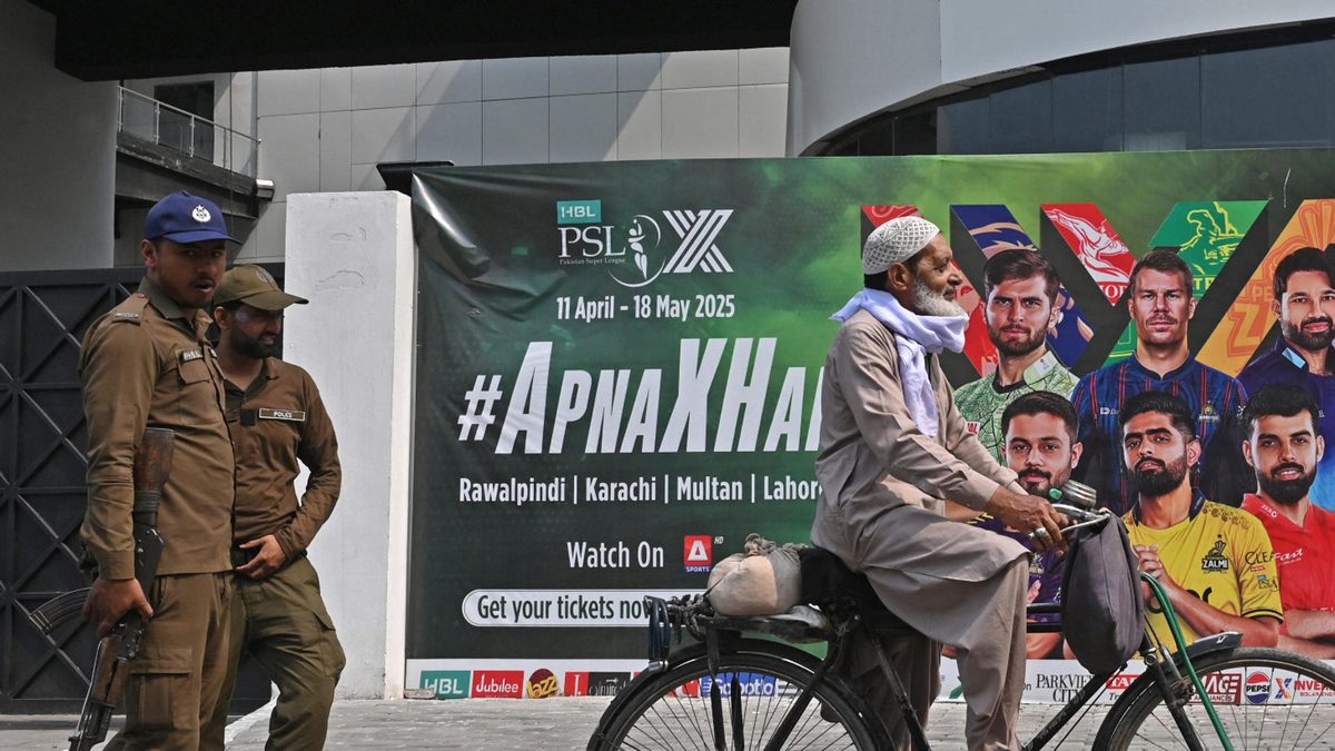 A cyclist rides past a hoarding outside the Gaddafi Cricket Stadium, one of the venues for the Pakistan Super League (PSL), in Lahore on May 9, 2025. Pakistan's T20 cricket league will be relocated to the United Arab Emirates, officials said on May 9, after Indian attacks on the country including a drone that reached Rawalpindi stadium