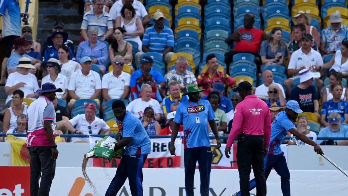 Groundstaff at Bridgetown in Barbados attempt to address a wet patch on the outfield during a rain delay in the first West Indies-England T20I