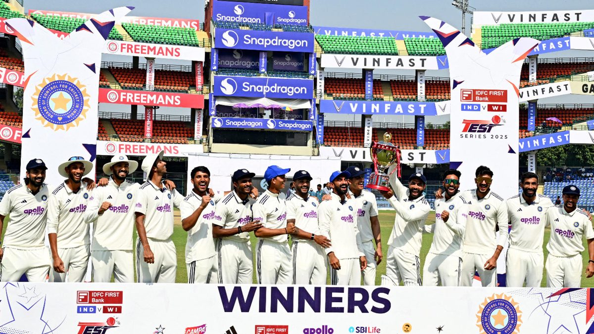 India's players celebrate with the trophy after their win against West Indies' at the end of the fifth day of the second and last Test cricket match between India and West Indies at the Arun Jaitley Stadium in New Delhi on October 14, 2025