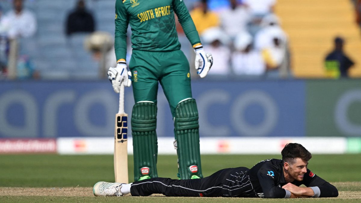 New Zealand's Mitchell Santner (bottom) reacts after dropping a catch as South Africa's Rassie van der Dussen watches during the 2023 ICC Men's Cricket World Cup one-day international (ODI) match between New Zealand and South Africa at the Maharashtra Cricket Association Stadium in Pune on November 1, 2023