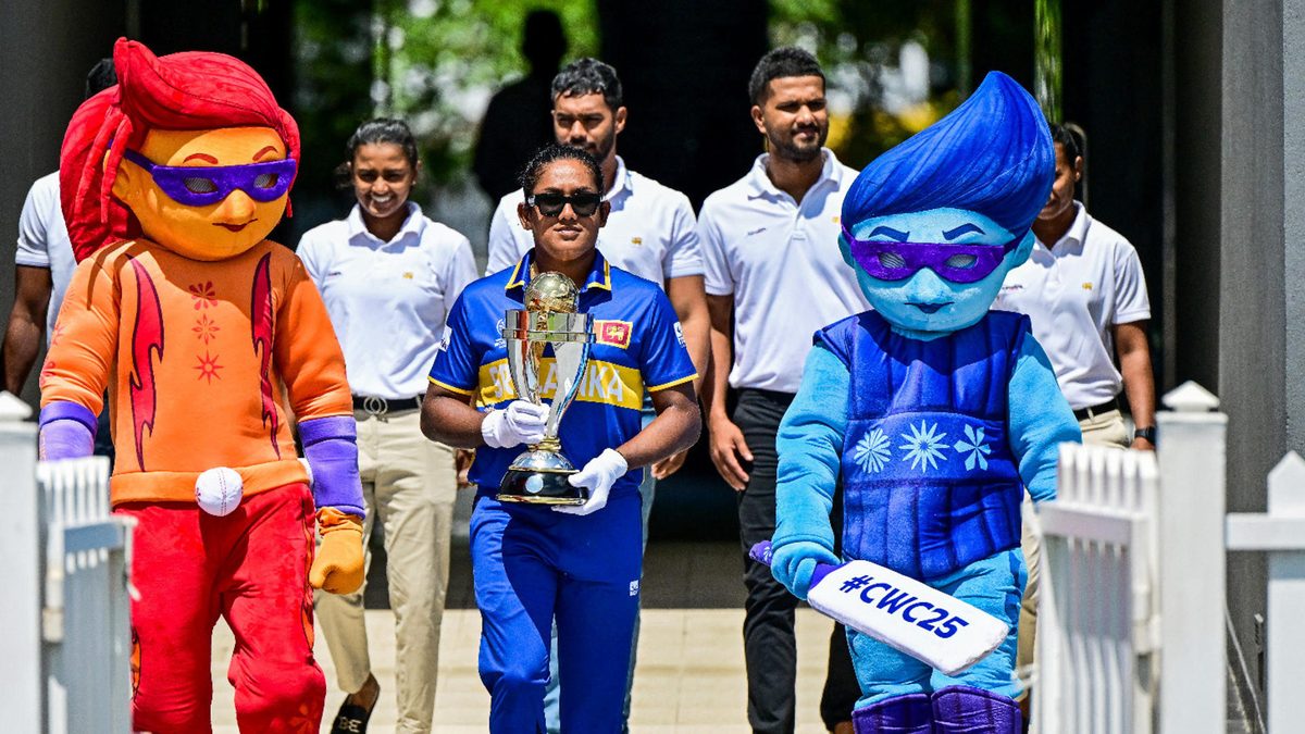 Sri Lanka's captain Chamari Athapaththu (C) holds the 2025 ICC Women's Cricket World Cup trophy as she walks alongside mascots Blaze (L) and Tonk during the trophy unveiling ceremony at the R. Premadasa International Cricket Stadium in Colombo on September 22, 2025