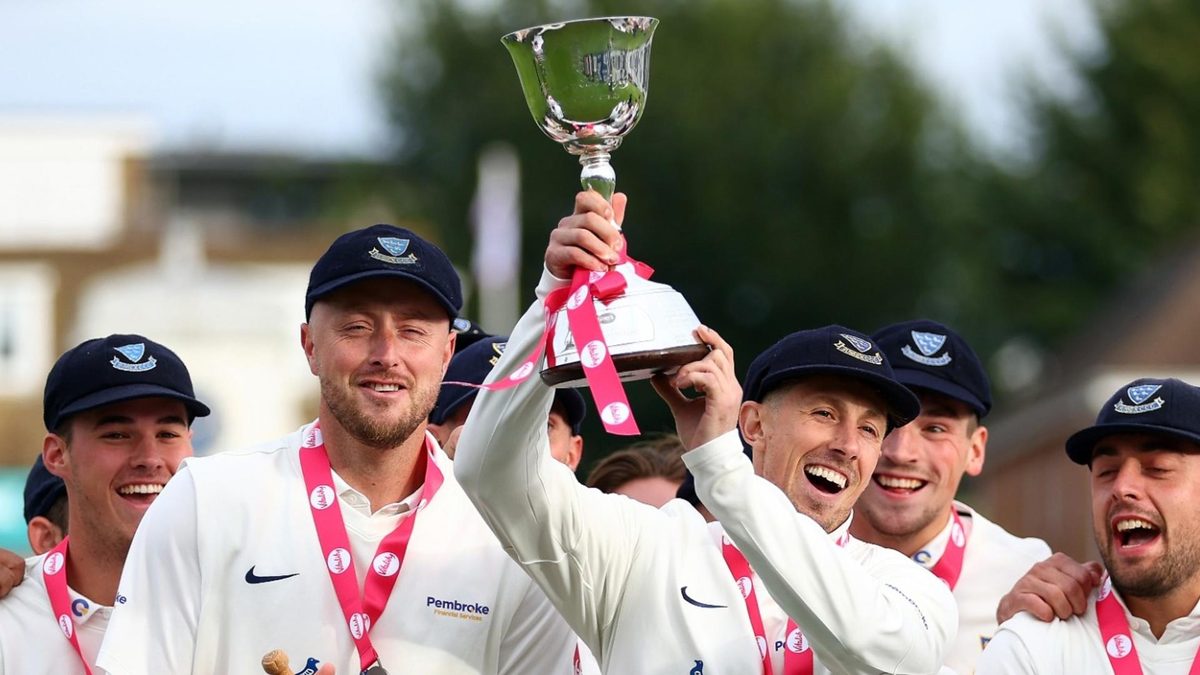 John Simpson lifts the Division Two trophy after Sussex won promotion in the County Championship