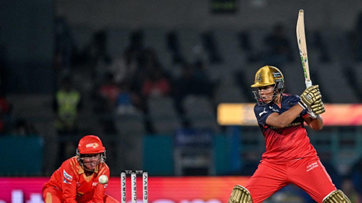 Royal Challengers Bengaluru's Richa Ghosh (R) plays a shot during the Women's Premier League (WPL) Twenty20 inaugural cricket match between Gujarat Giants and Royal Challengers Bengaluru at the Kotambi Stadium in Vadodara on February 14, 2025
