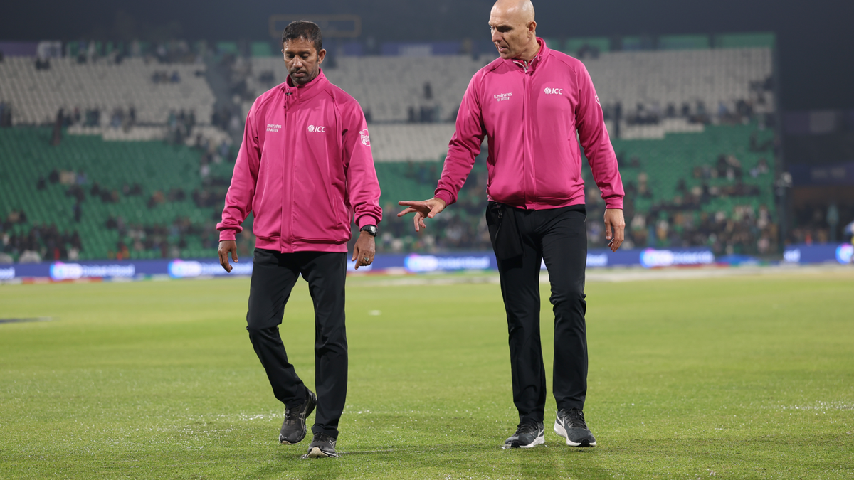 Umpires Kumar Dharmasena and Alex Wharf inspect the outfield for a rain-curtailed match