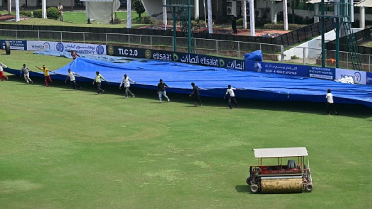 Groundstaff cover the field during day two of the AFG vs NZ Test match after the umpires called off the day's play due to a wet outfield