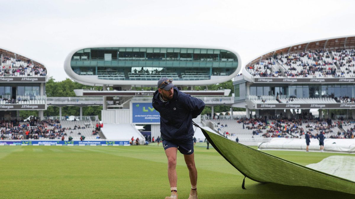 Groundstaff remove rain covers from the pitch ahead of start of play on the third day of the first cricket Test match between England and New Zealand at Lord's cricket ground in London on June 4, 2022