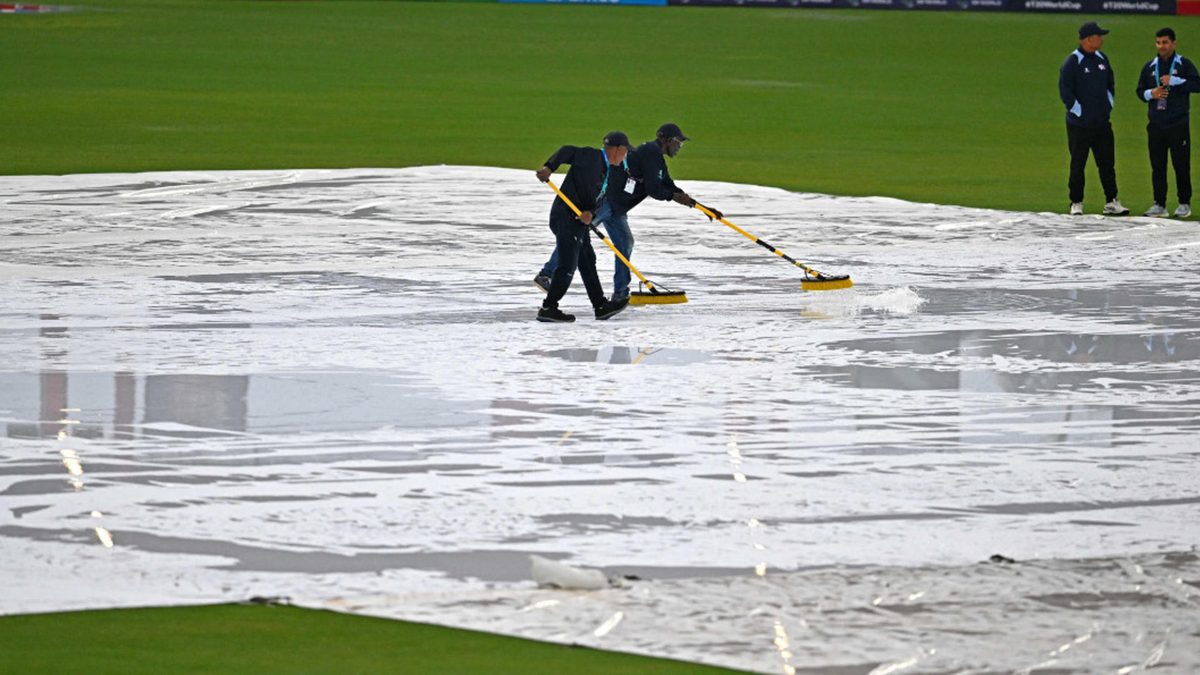 Match officials wipe water from the pitch as it rains ahead of the ICC men's Twenty20 World Cup 2024 group D cricket match between Sri Lanka and Nepal at Central Broward Park & Broward County Stadium in Lauderhill, Florida on June 11, 2024.