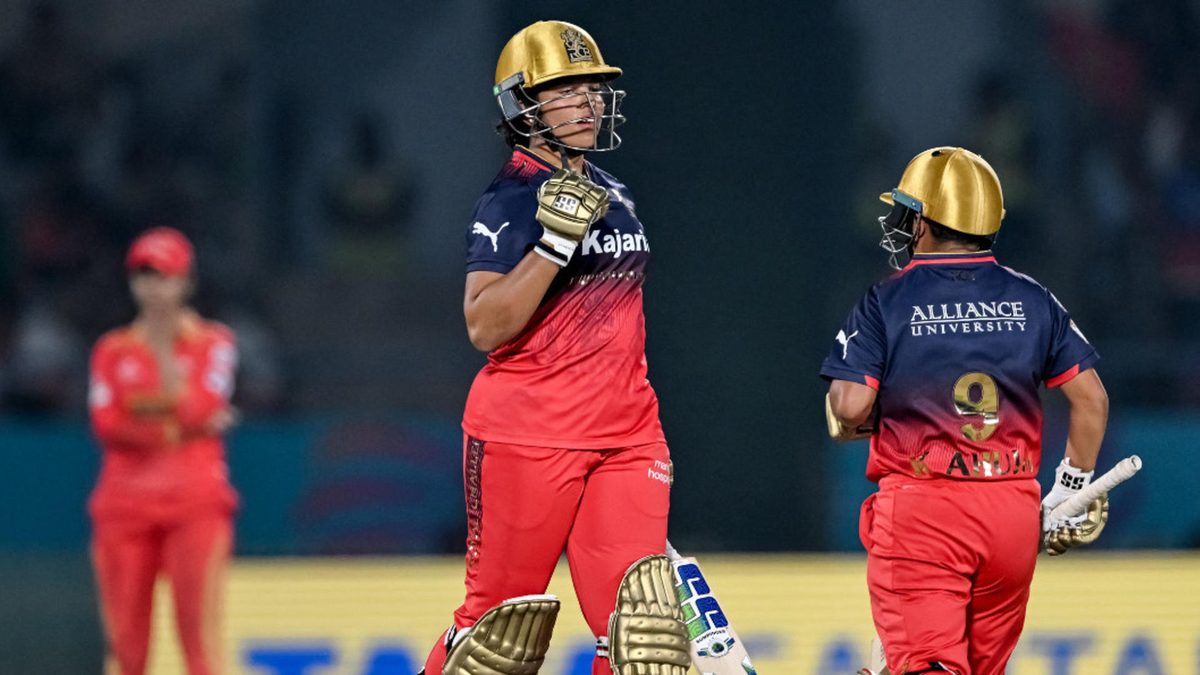 Royal Challengers Bengaluru's Richa Ghosh (C) celebrates after scoring a half-century (50 runs) during the Women's Premier League (WPL) Twenty20 inaugural cricket match between Gujarat Giants and Royal Challengers Bengaluru at the Kotambi Stadium in Vadodara on February 14, 2025