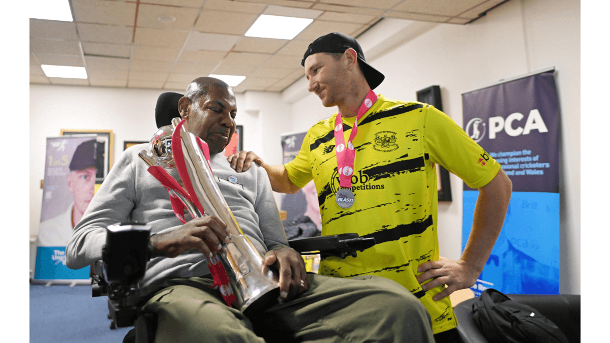 Syd Lawrence, Gloucestershire's president, is handed the T20 Blast trophy by James Bracey.